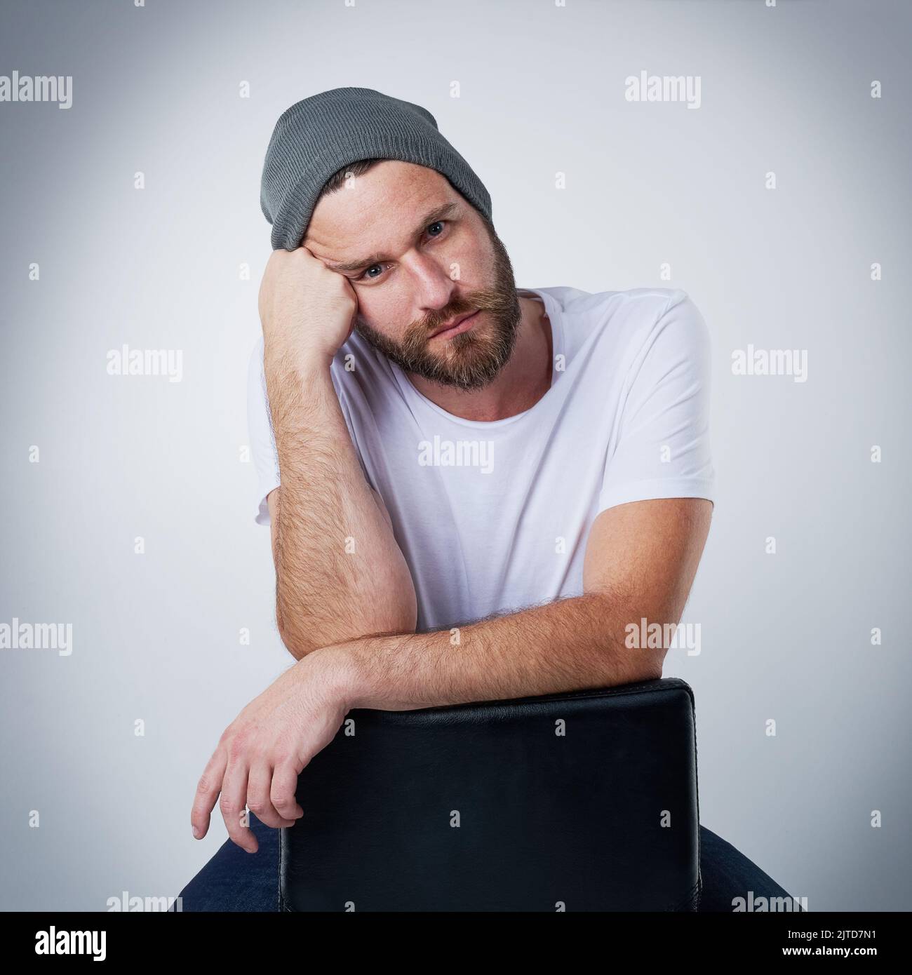 Im tired of being photographed. Portrait of a moody young man posing on a chair in the studio. Stock Photo