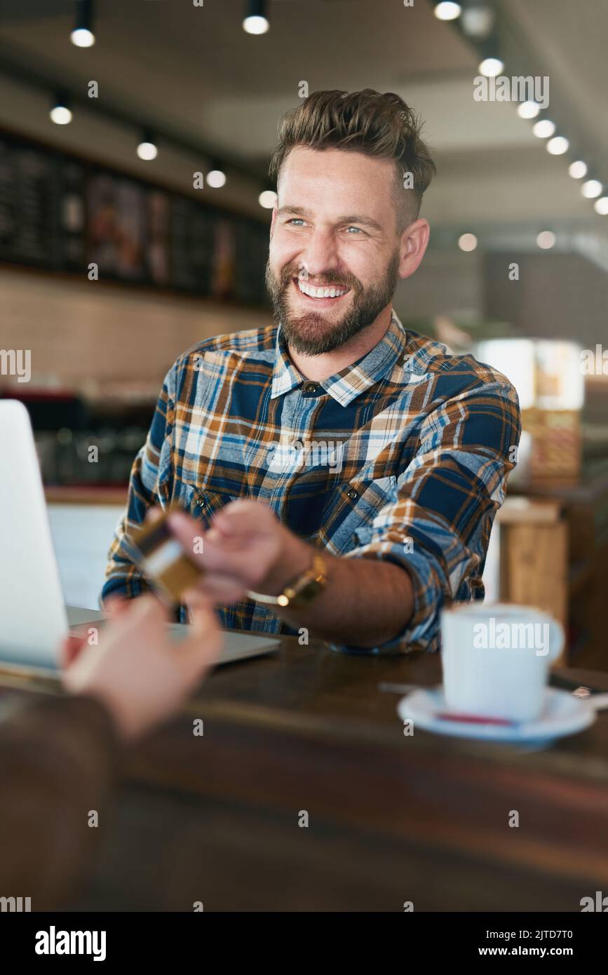 Hes happy to tip for good service. a young man paying with a credit