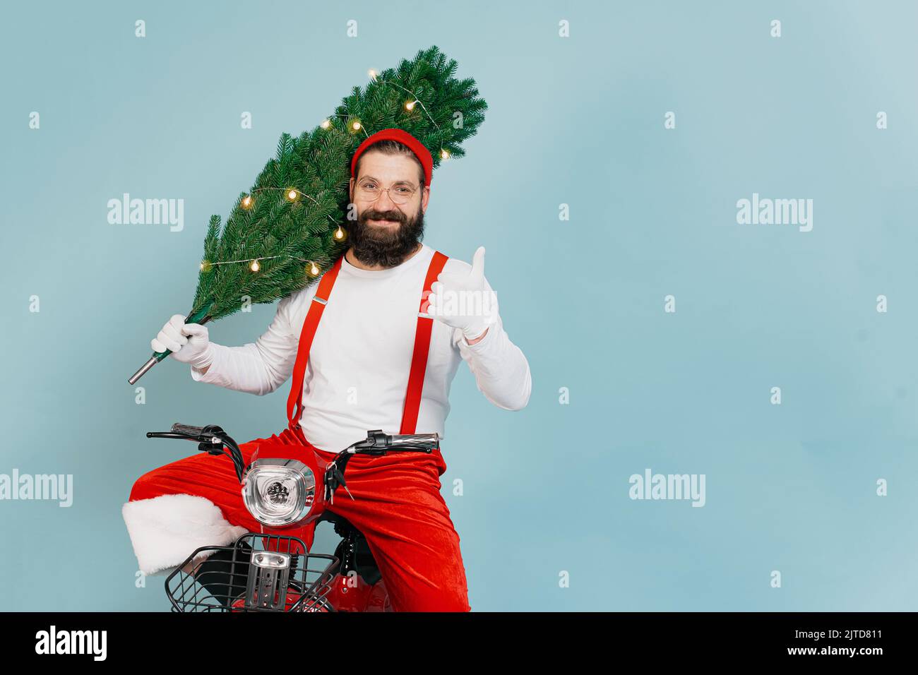 A hipster in a red cap, big heart-shaped glasses, santa pants with