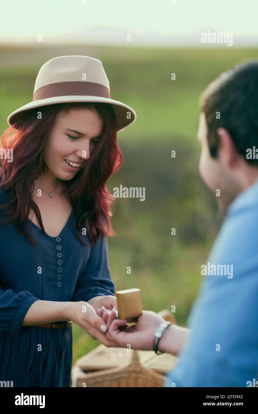 Shes taken aback by the beautiful moment. a man proposing to his girlfriend with an engagement ring in a box. Stock Photo