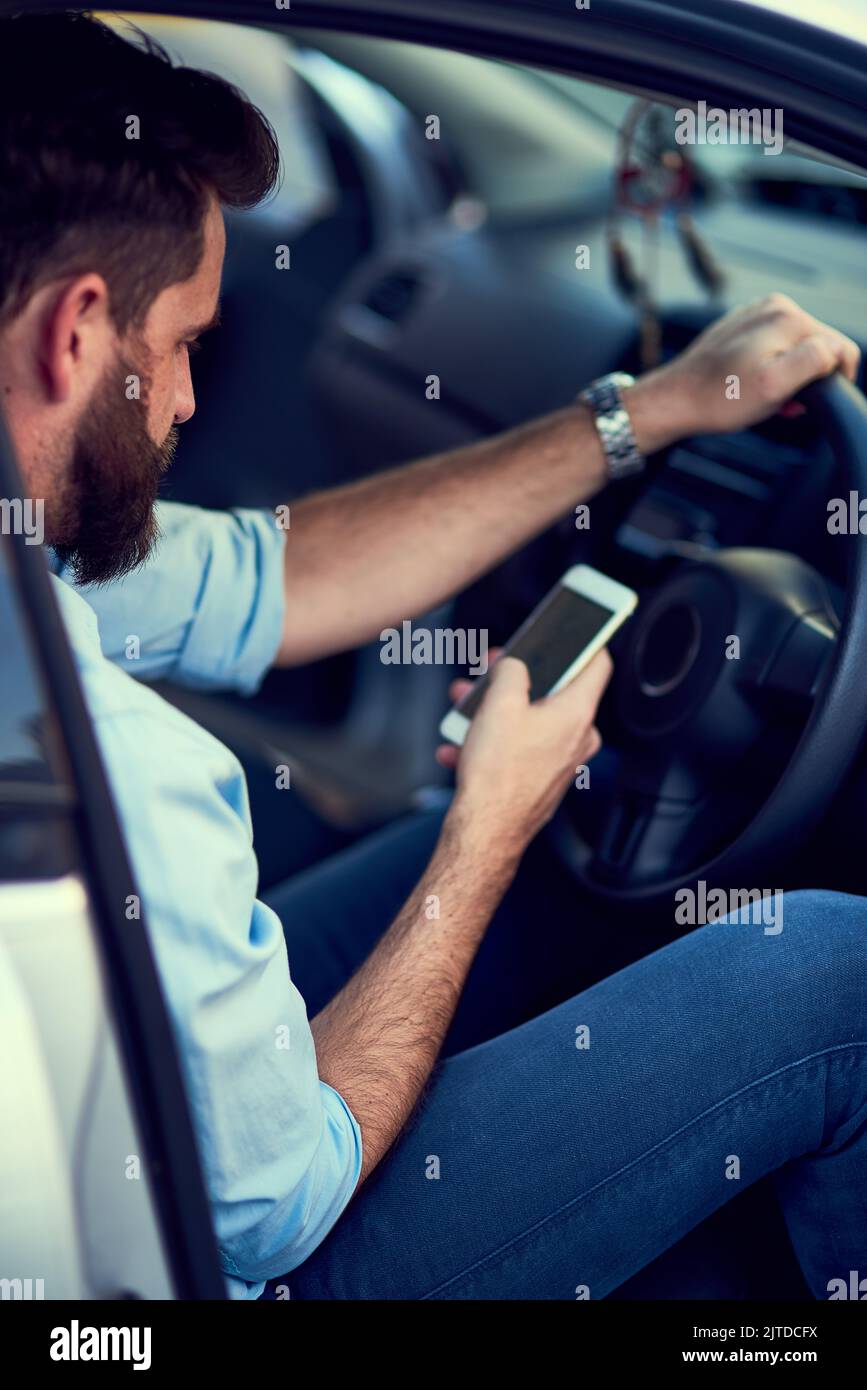 Navigating is easy when you have a phone. a unrecognizable man using his phone while driving to a destination. Stock Photo