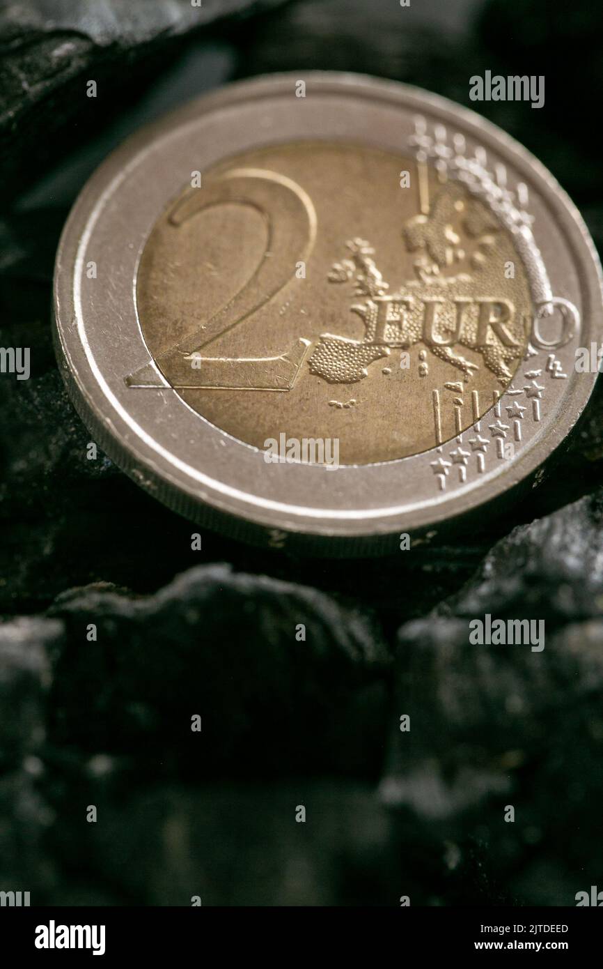 Coal cost. euro coin on a piece of coal closeup. Heating with coal