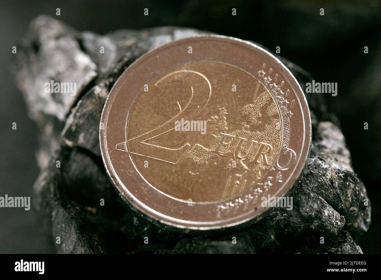 Coal cost. euro coin on a piece of coal closeup.Buying and selling