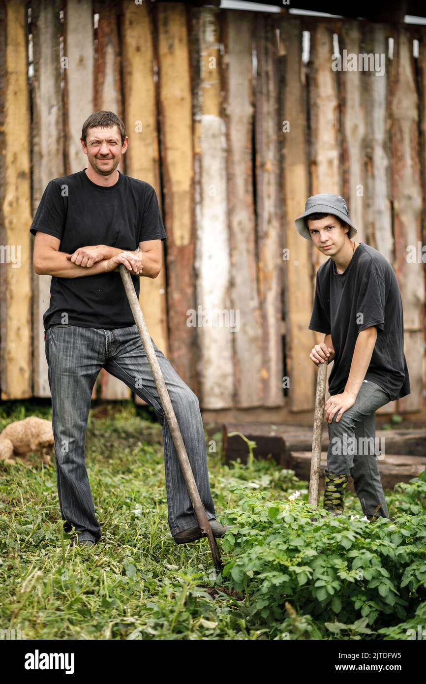 local agriculture, farmer's day 12 october. a man in a black t-shirt with a pitchfork, natural products with his own hands. High quality photo Stock Photo