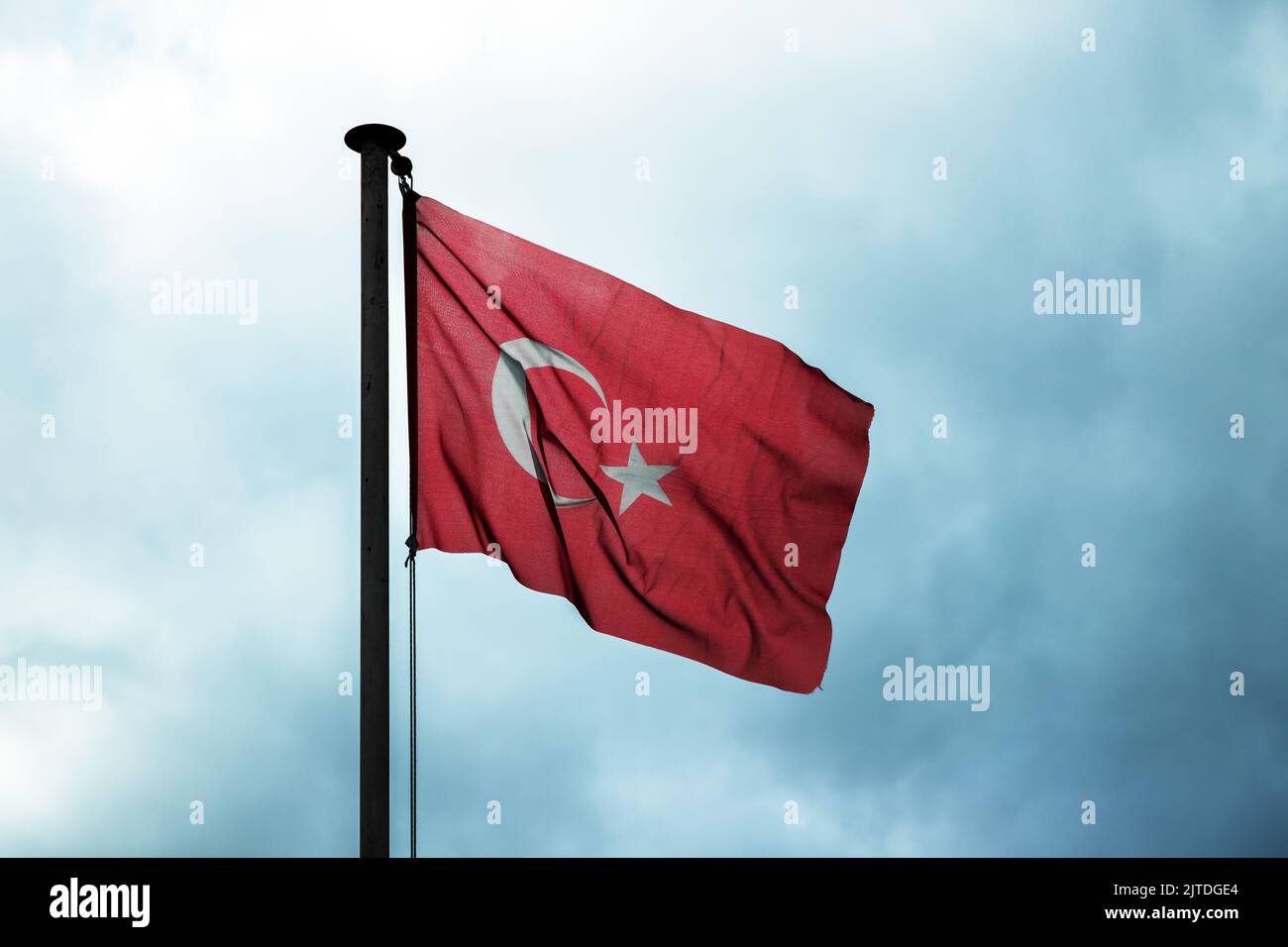 Flag of Turkey is under dark cloudy sky, close up photo Stock Photo