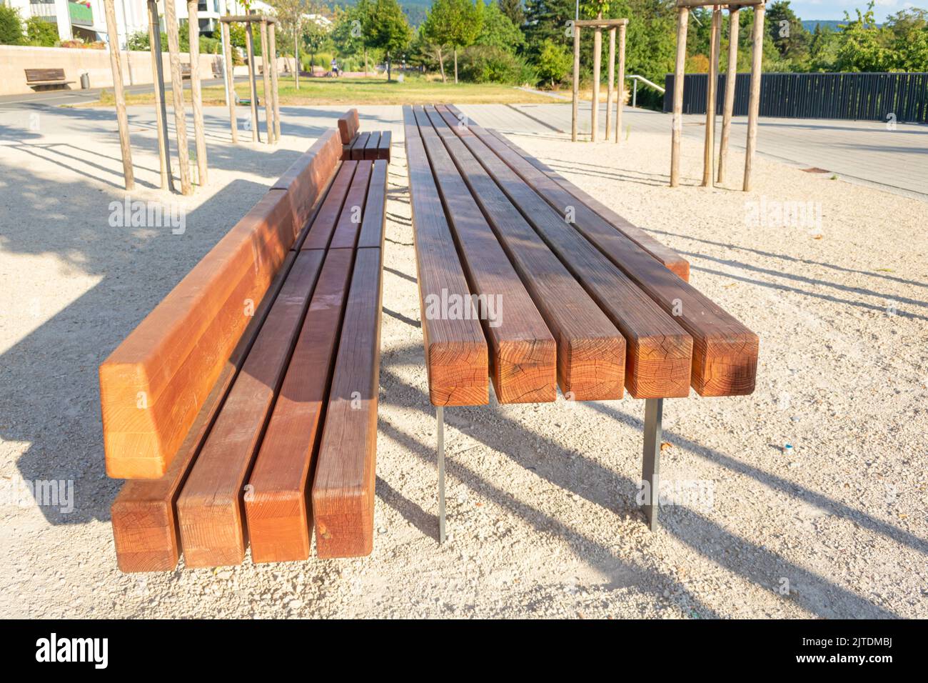 long wooden bench and solid wooden table in a public area of a new development to increase the quality of stay Stock Photo