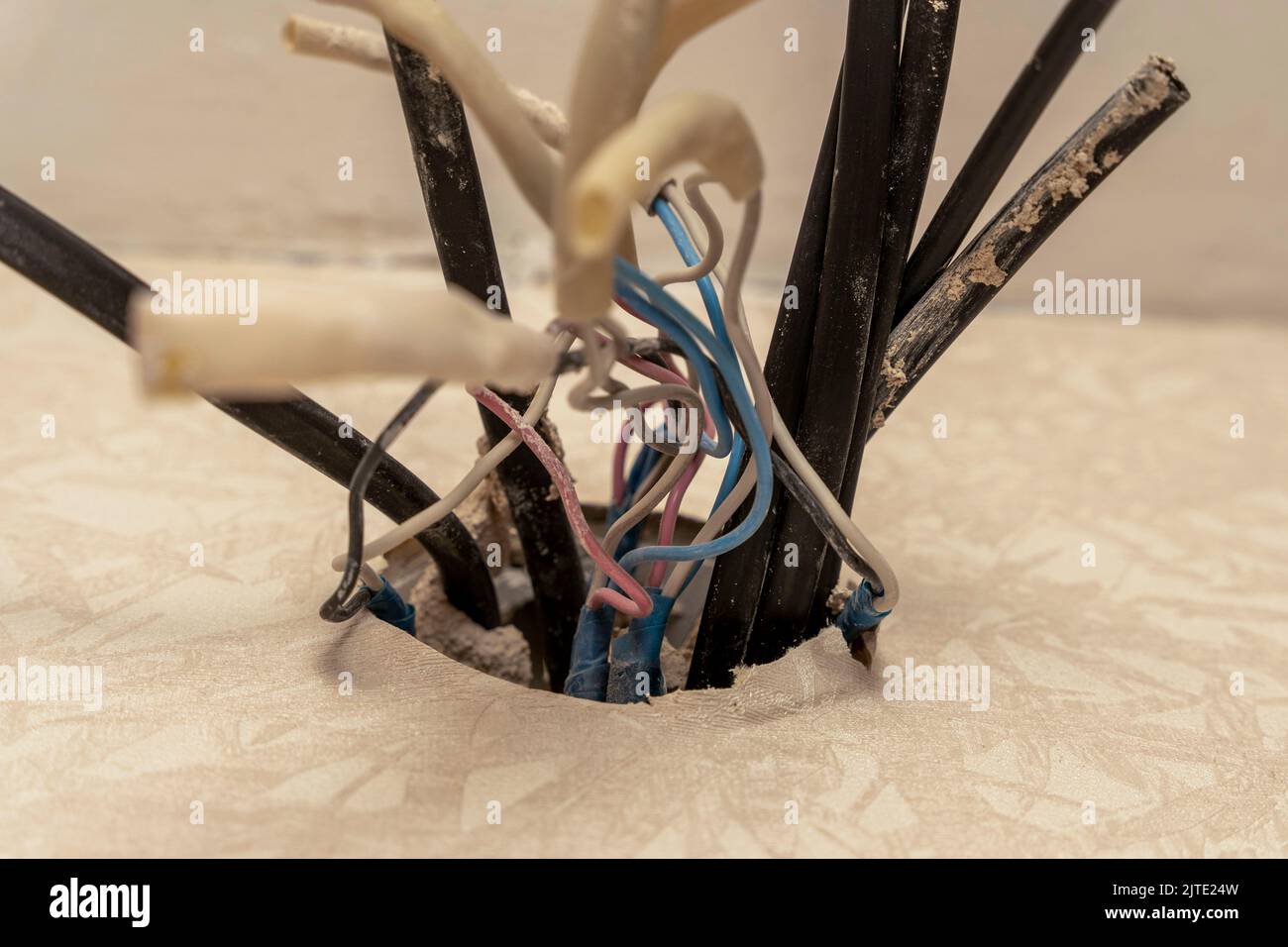 old electrical wires are sticking out of the mounting box in the wall