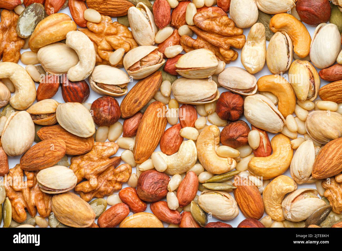 Background from different types of nuts and seeds peeled walnut, hazelnuts, peeled peanut