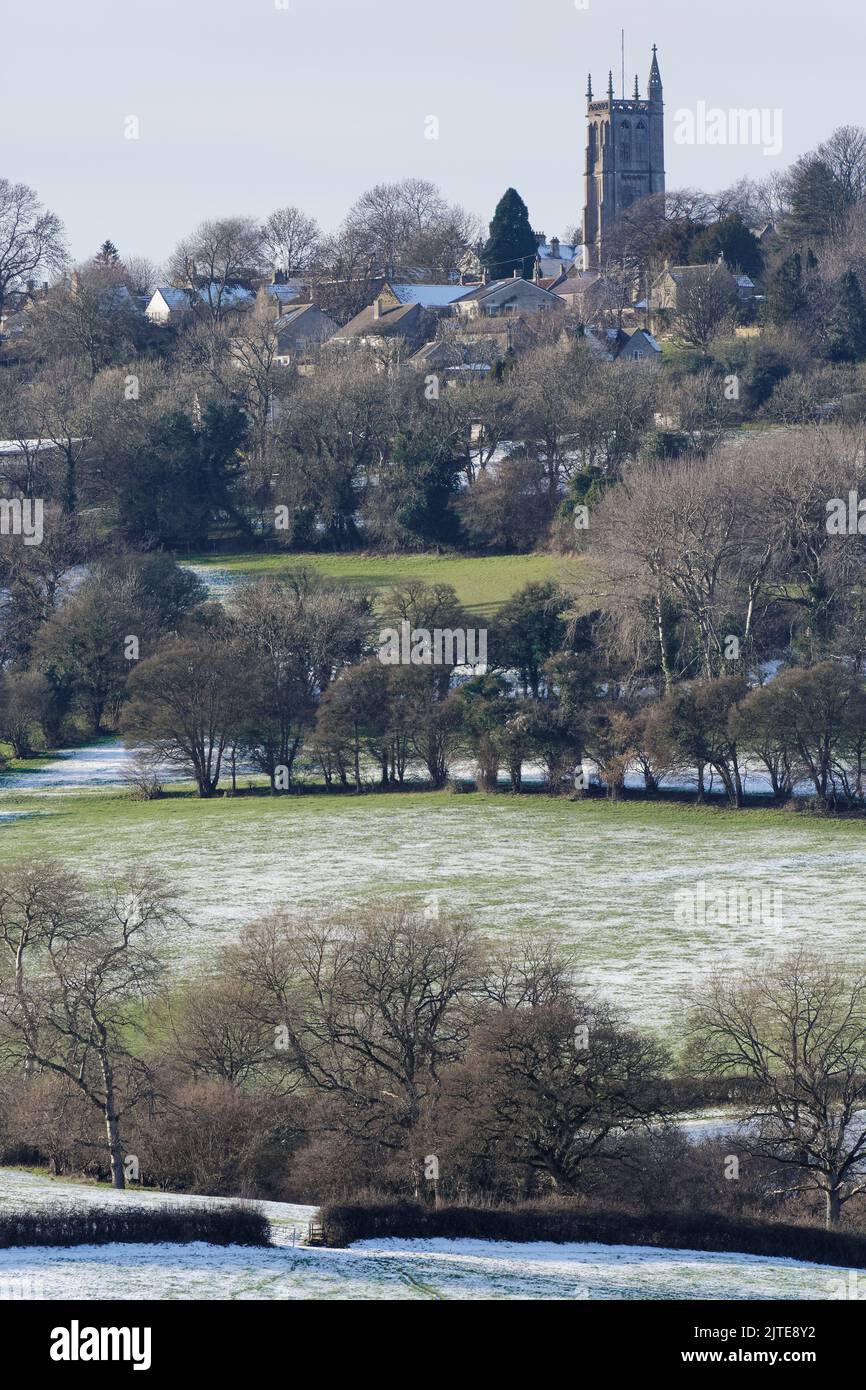 Snow-dusted pastureland with  the By Brook valley, Colerne village and St. John The Baptist church in the background, Wiltshire, UK, January 2021. Stock Photo