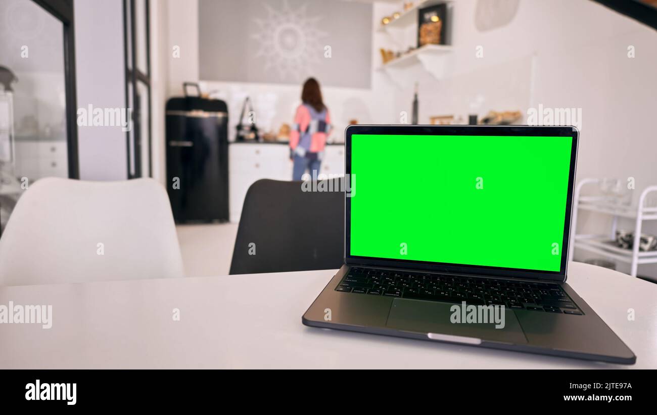 A closeup of notebook with green screen chroma key background on table Stock Photo
