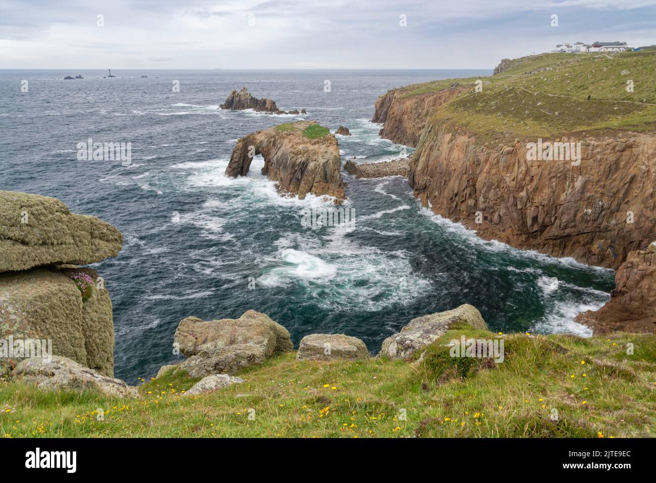 View towards Enys Dodnan rock arch, and the Armed Knight rock stack from Pordenack Point on a stormy day, Land’s End, Cornwall, UK, June 2021. Stock Photo
