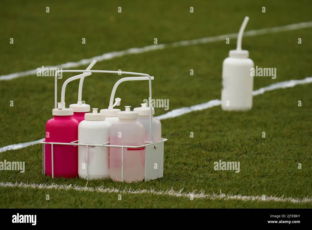 Water bottles for american football players on green grass at the edge of the playing field. Team sport concept Stock Photo