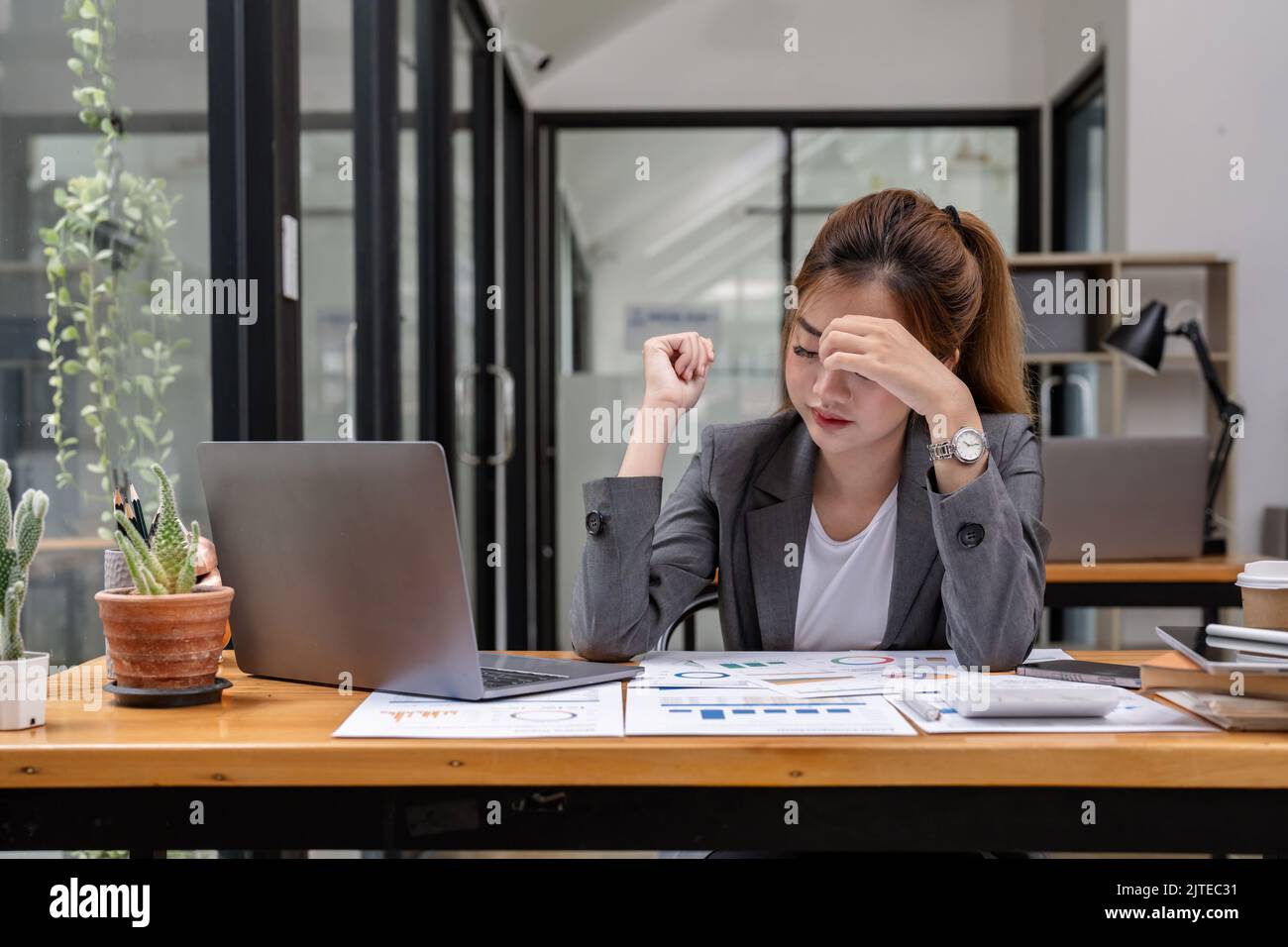 Stressed business woman working from home on laptop looking worried, tired and overwhelmed. Stock Photo