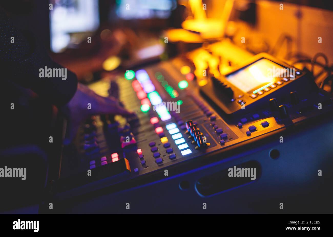 View of lighting technician operator working on mixing console