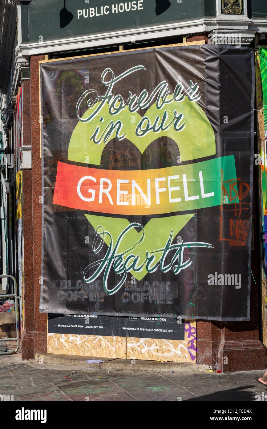 Grenfell support banner at the Notting Hill Carnival, on August Bank Holiday Monday 2022 in London, UK. Grenfell, forever in our hearts. Closed pub Stock Photo