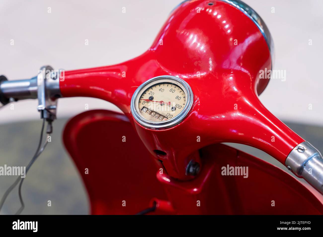 headlight, handlebar and control levers of a vintage red scooter Stock
