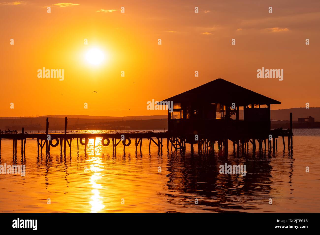 Sunset over the sea lake and old wooden pier, romantic travel destination, nature landscape Stock Photo