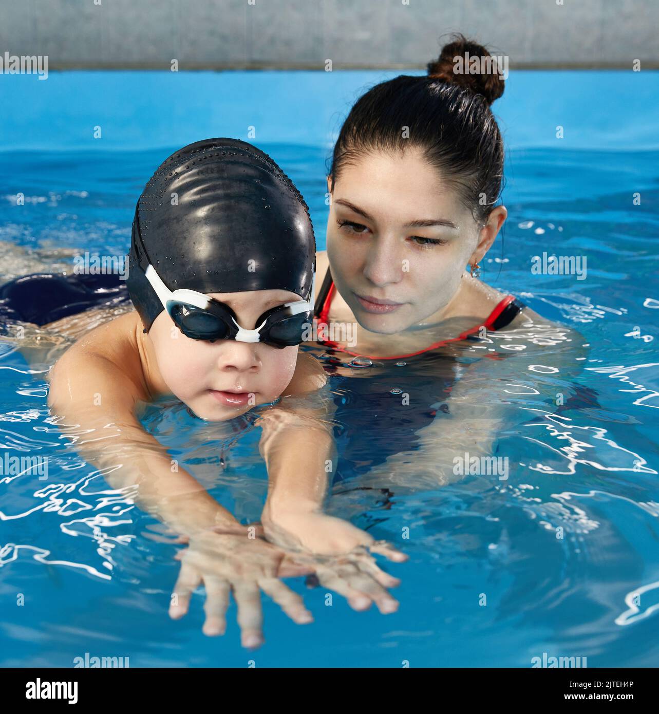 Little boy learning to swim in pool with teacher Stock Photo Alamy