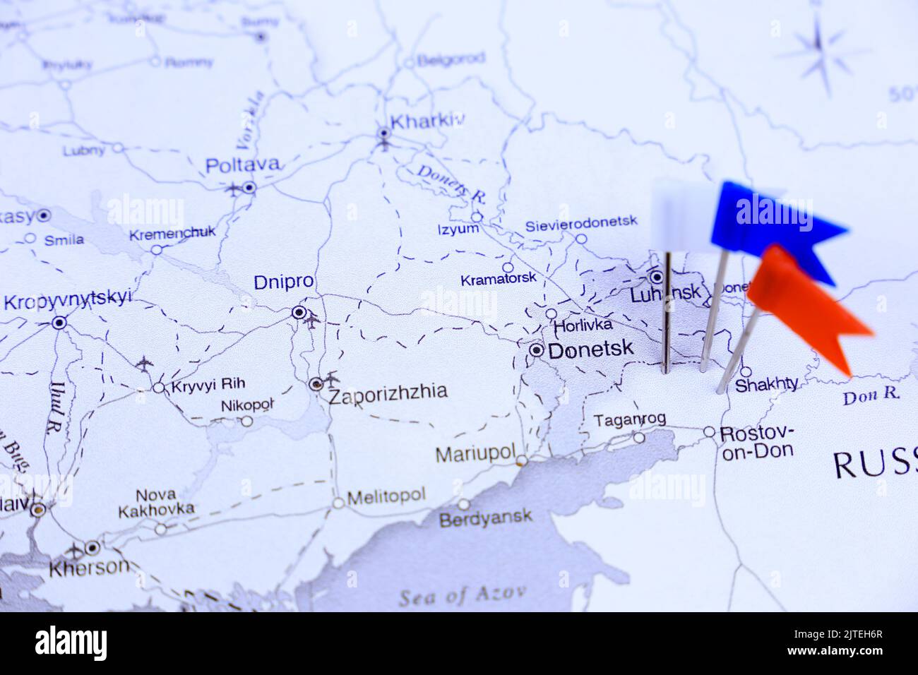 White, Blue and Red pointing flags on Russian border on white map Stock Photo