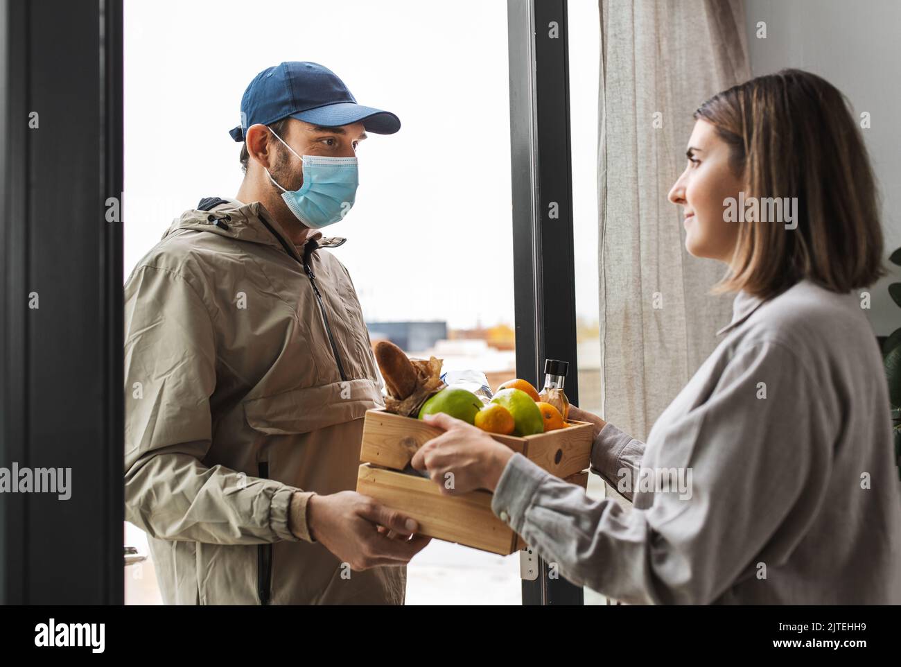 food delivery man in mask giving order to customer Stock Photo Alamy