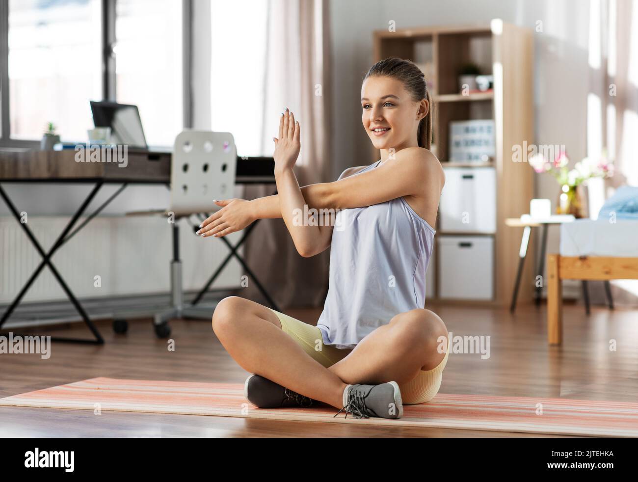 happy teenage girl exercising on yoga mat at home Stock Photo - Alamy