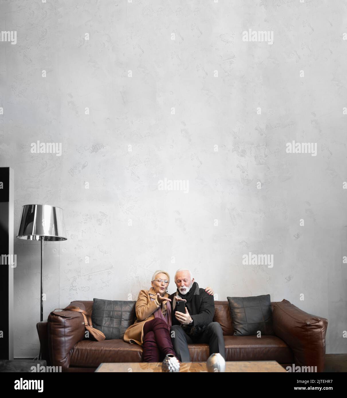 Elderly couple blowing kisses to their friends and family with the smartphone Stock Photo