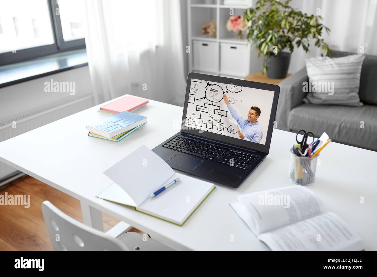 laptop with male teacher on screen on table Stock Photo Alamy