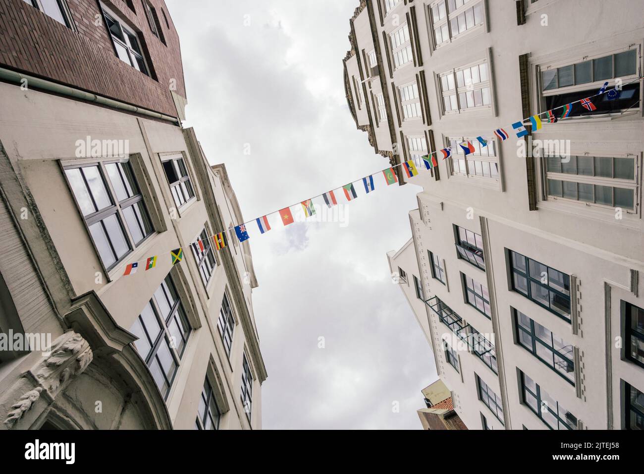 two house fronts are connected by a line with different flags Stock Photo