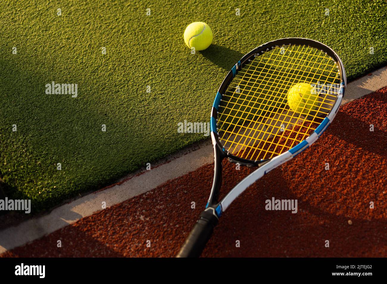 tennis balls and racket on the green grass background Stock Photo - Alamy