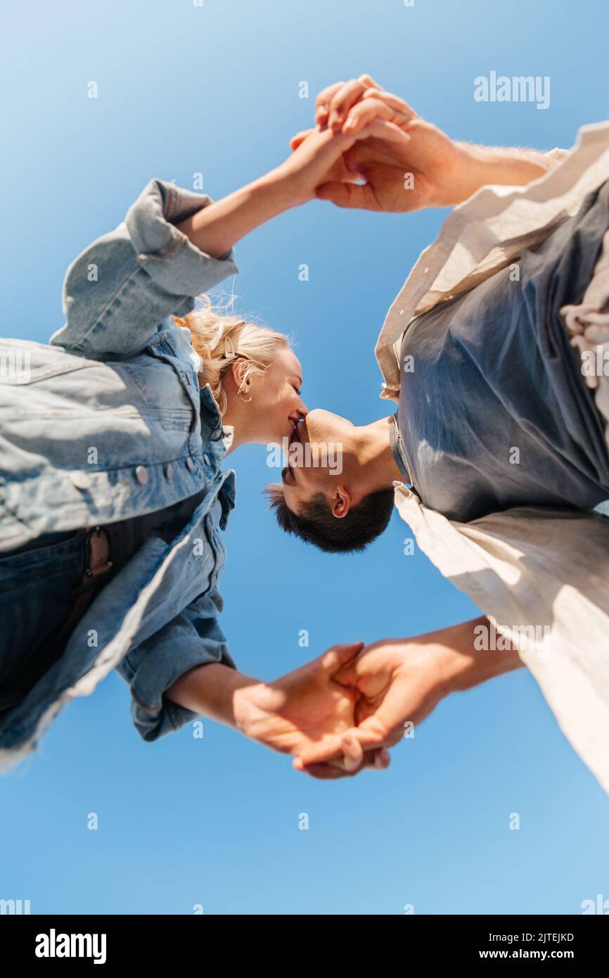 happy young couple kissing under blue sky Stock Photo Alamy