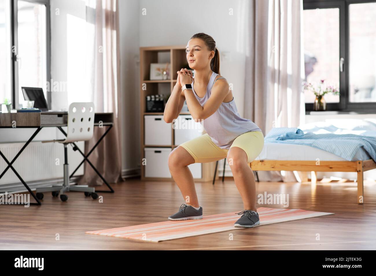 happy teenage girl exercising on yoga mat at home Stock Photo - Alamy