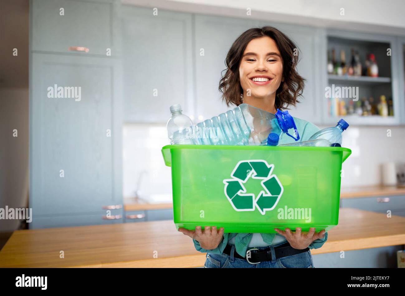 happy young woman sorting plastic waste on kitchen Stock Photo - Alamy