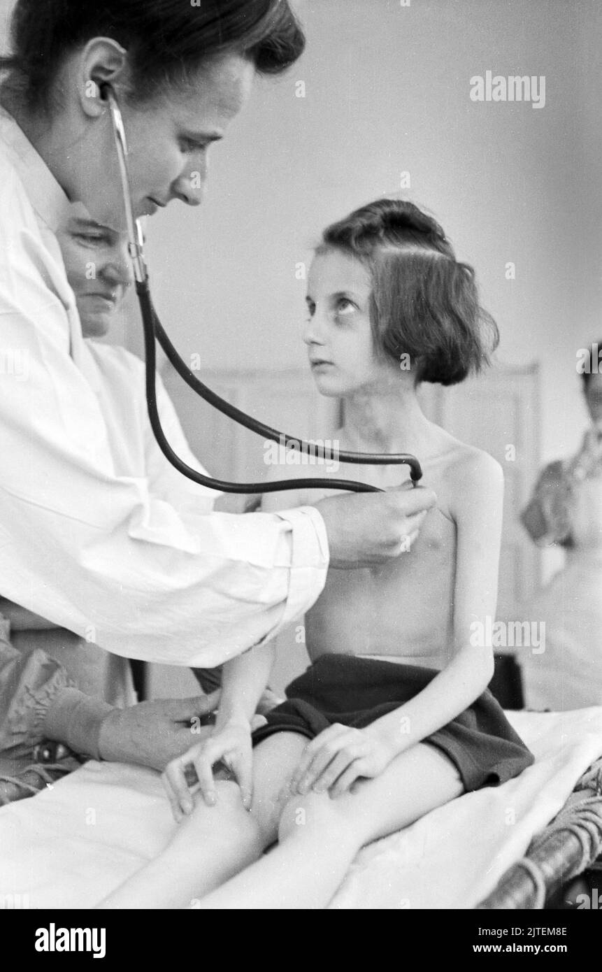 Kampf der Tuberkulose im TBC Kinderkrankenhaus in Neukölln, hier eine Ärztin bei der Untersuchung eines kleinen Mädchens, Berlin, Deutschland 1947. Stock Photo