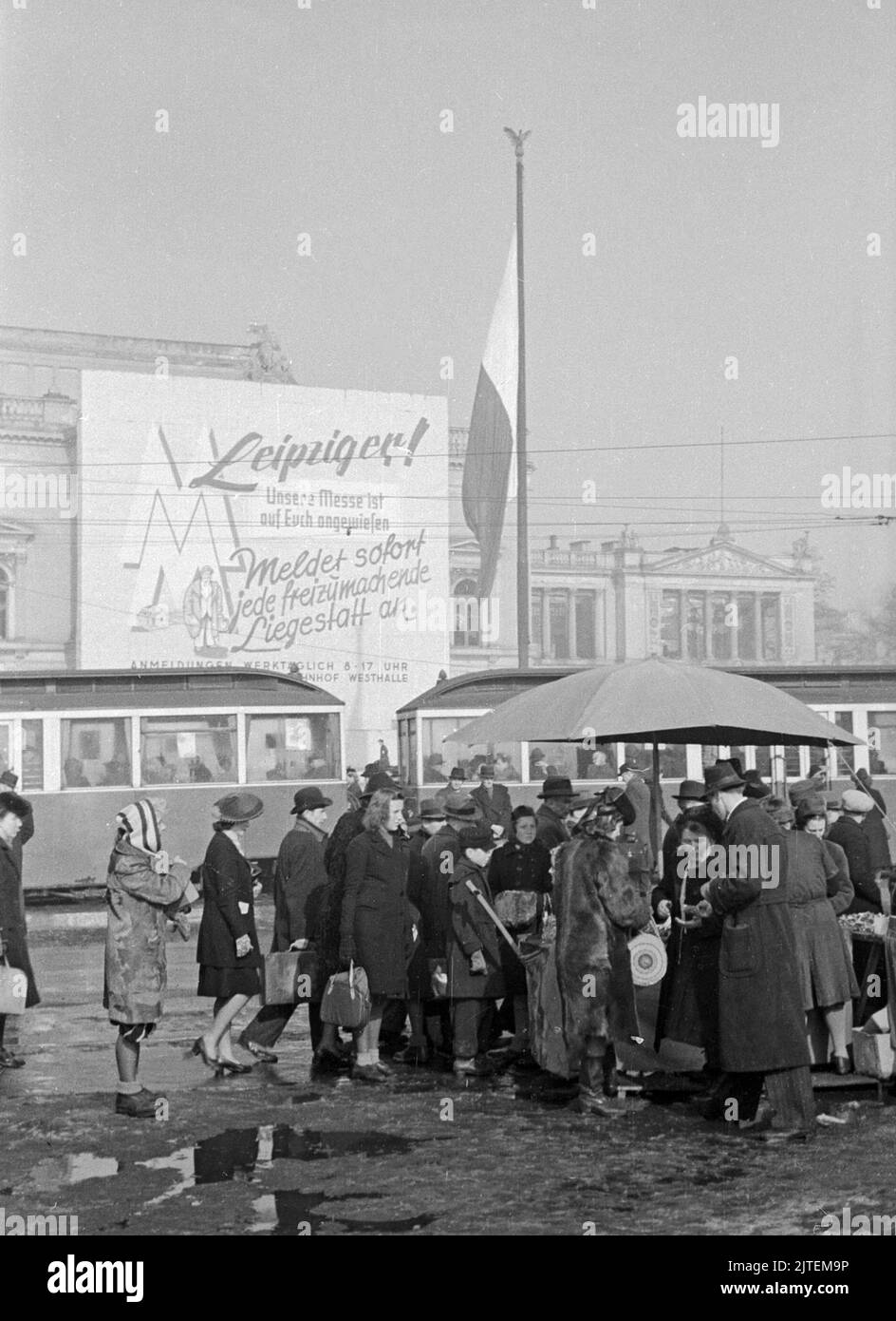 Öffentlicher Aufruf mit der Bitte um Meldung von Liegeplätzen für Besucher der Frühjahrsmesse in Leipzig, davor Werbewagen und Menschen, Deutschland 1947. Stock Photo