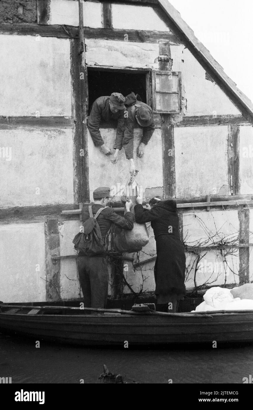 Anwohner packen ihre Habseligkeiten in ein Paddelboot bei der Evakuierung während der Hochwasserkatastrophe im Dorf Neutrebbin, Deutschland 1947. Stock Photo