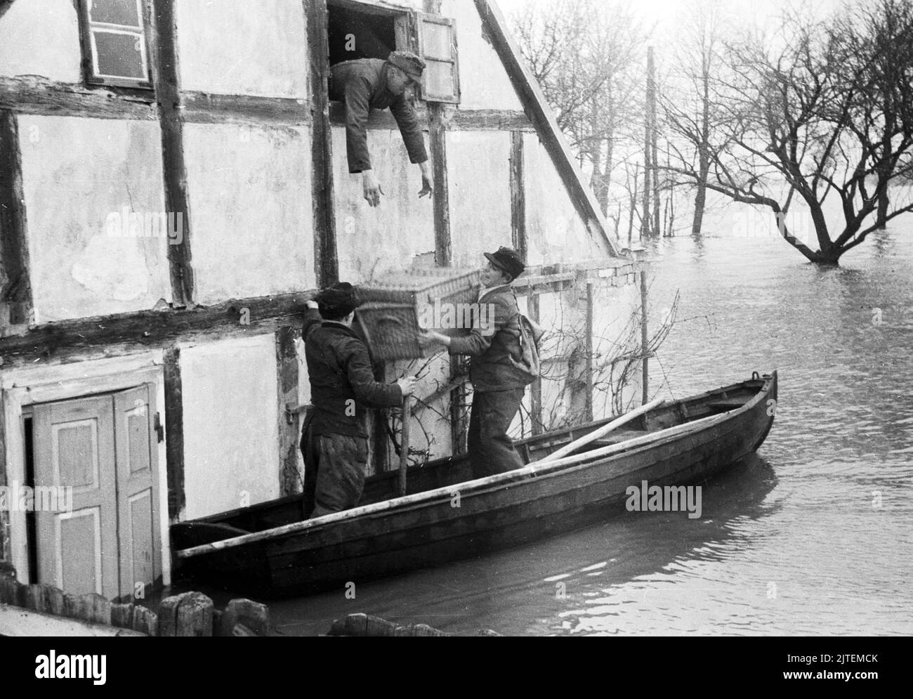 Anwohner packen ihre Habseligkeiten in ein Paddelboot bei der Evakuierung während der Hochwasserkatastrophe im Dorf Neutrebbin, Deutschland 1947. Stock Photo