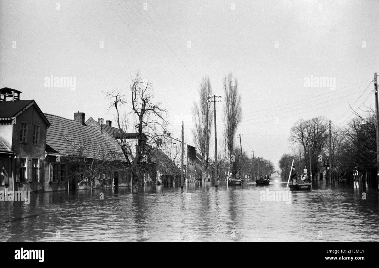 Anwohner auf Booten in den überfluteteten Straßen während der Hochwasserkatastrophe im Dorf Neutrebbin, Deutschland 1947. Stock Photo