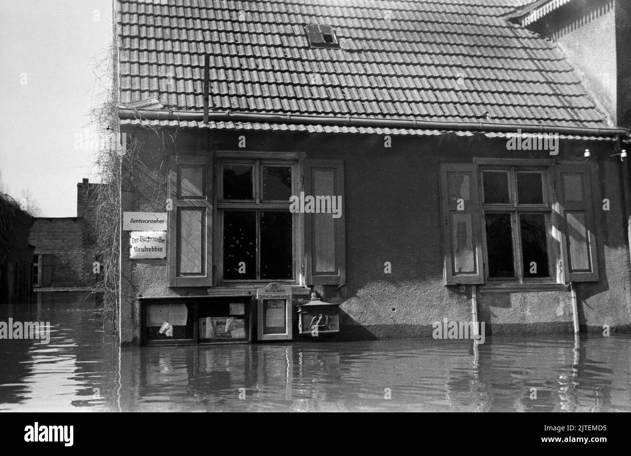 Bis hoch in das Erdgeschoss steht das Wasser auch im Bürgermeisteramt während der Hochwasserkatastrophe im Dorf Neutrebbin, Deutschland 1947. Stock Photo