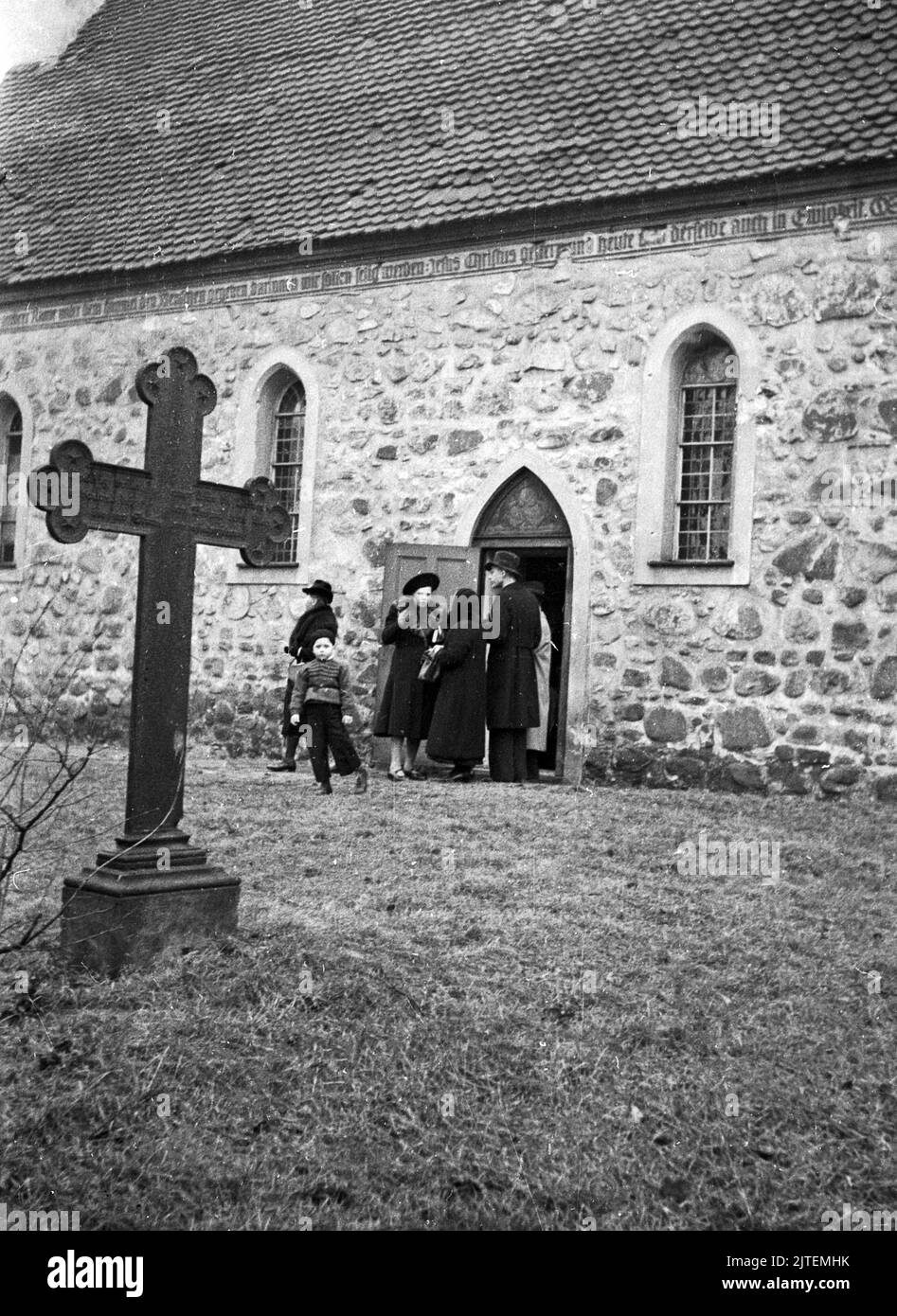 Gläubige vor einer Brotsammlung vor der alten Dorfkirche in