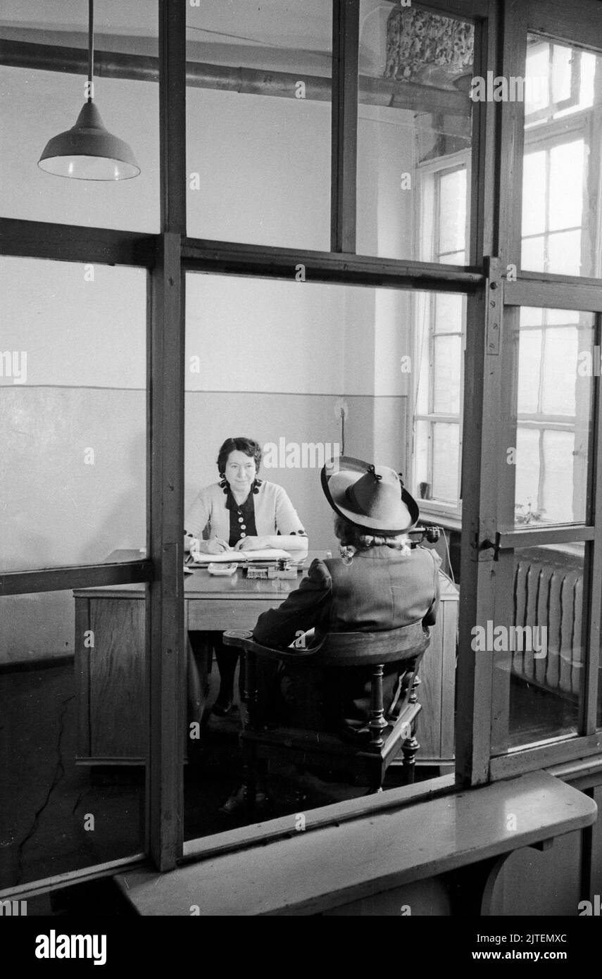 Gespräch zweier Frauen in einem Büro der Mützenfabrik Wolfgang Schmidt in der Greifswalder Strasse 220 in Berlin, Deutschland 1947. Stock Photo