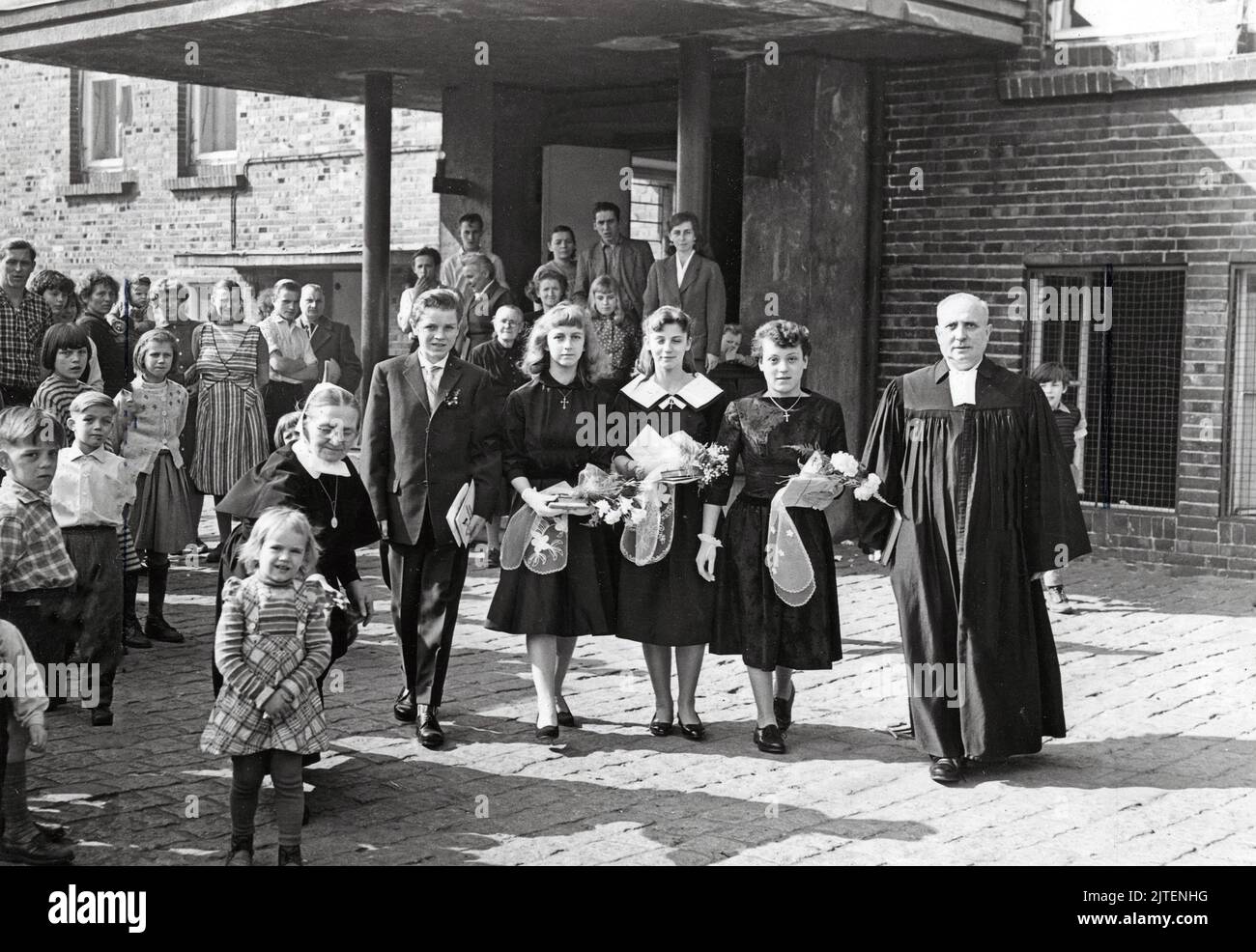 Ein Geistlicher mit seinen Konfirmandinnen nach deren Konfirmation im  Flüchtlingslager, Berlin, Deutschland 1960 Stock Photo - Alamy