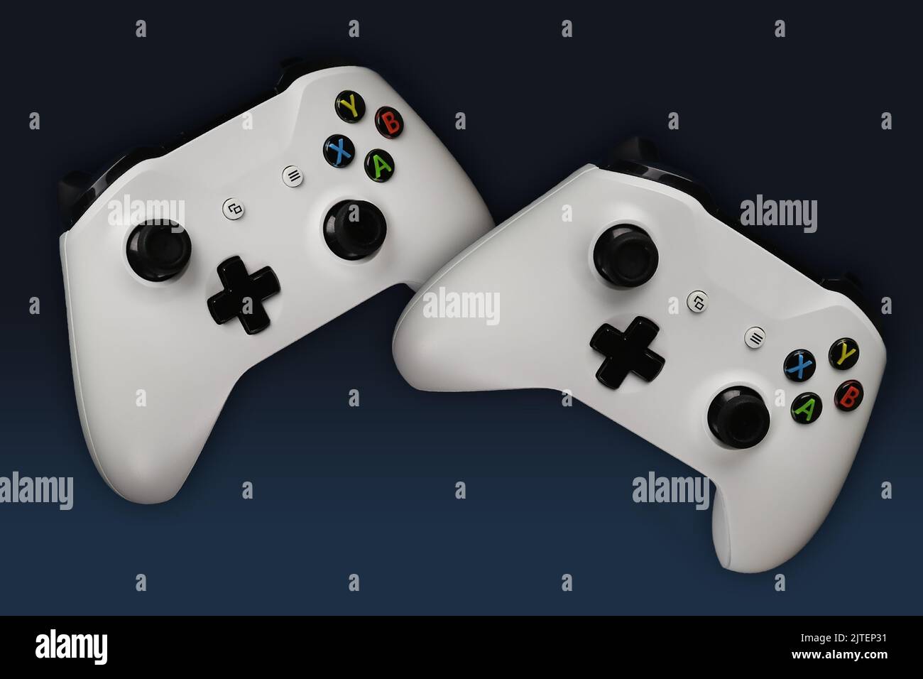 Two gaming gamepads in flight on a blue gradient background Stock Photo