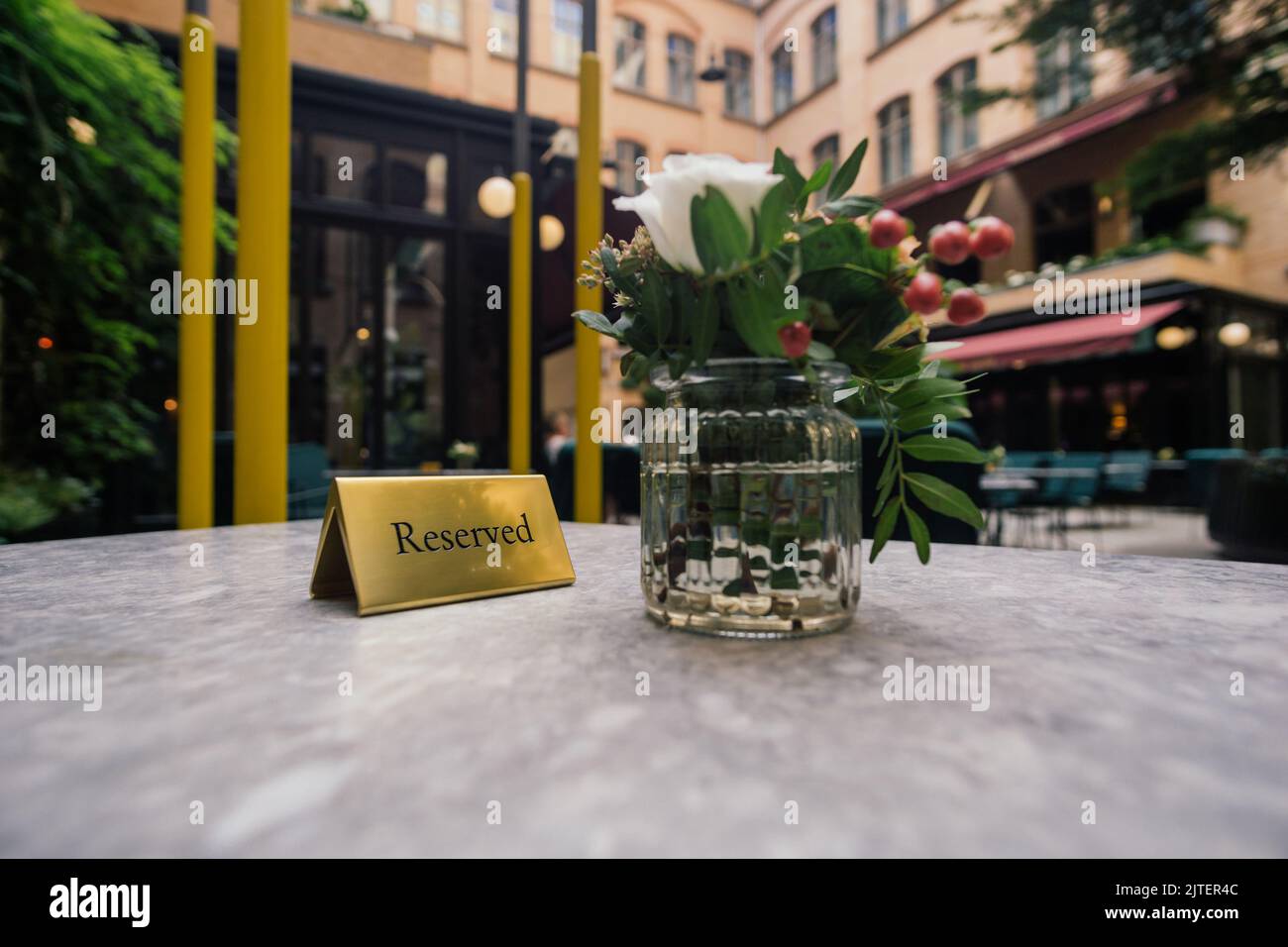 Reserved sign and vase of flowers on a restaurant table Stock Photo - Alamy