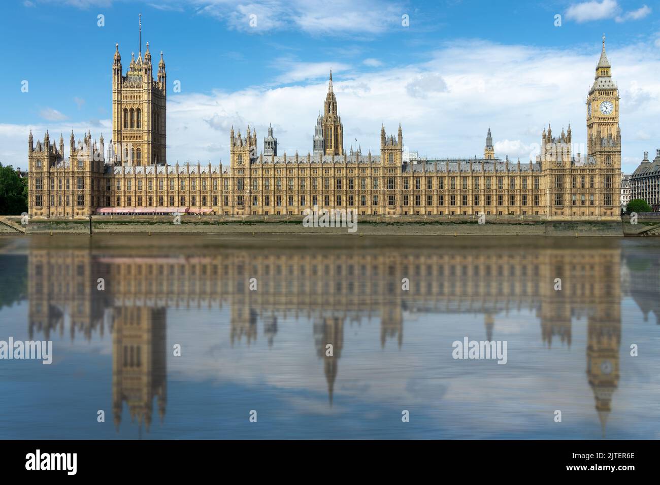 Houses of the UK parliament in Westminster palace, water reflections in the Thames river, London Stock Photo