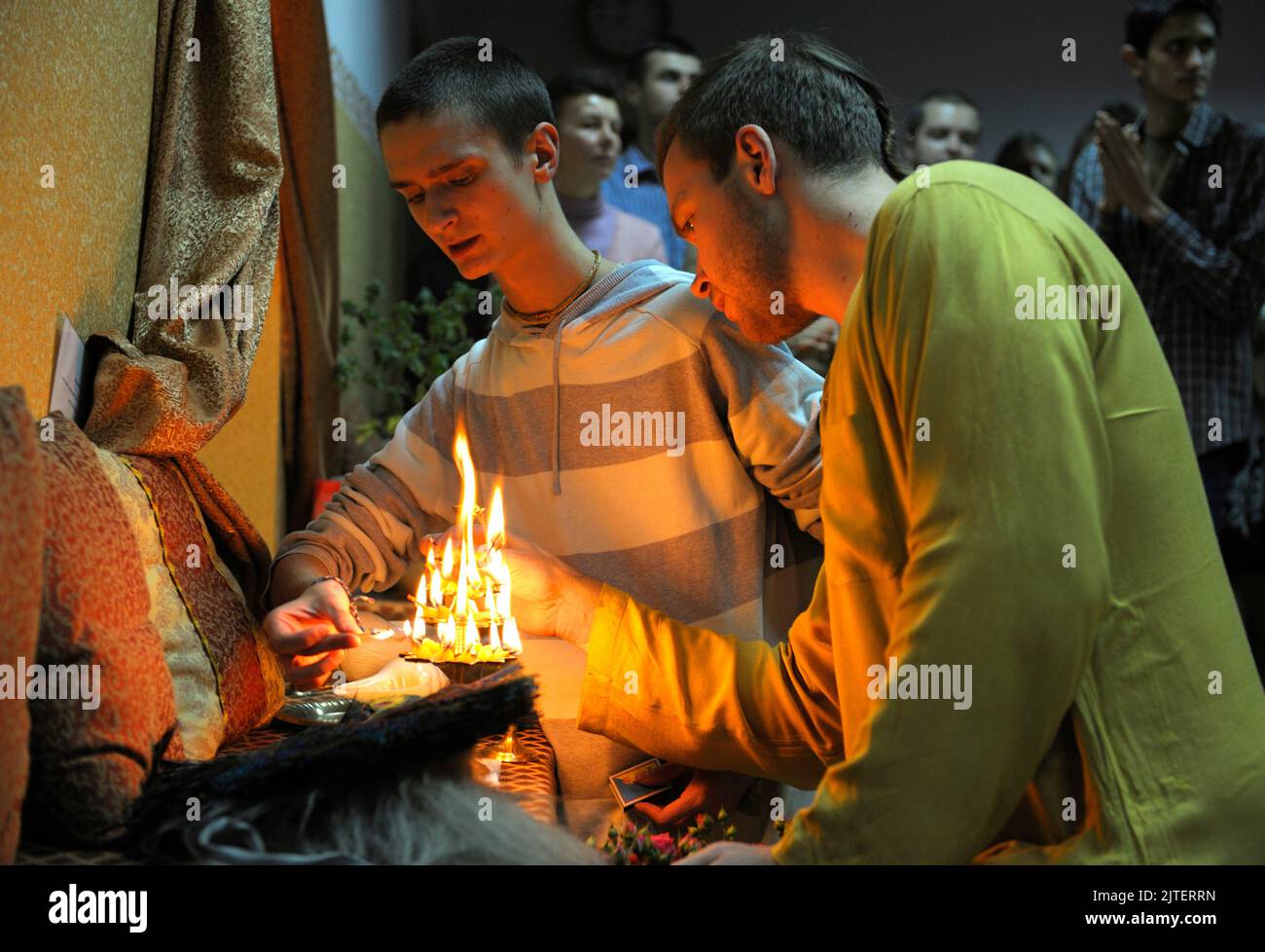 Krishna monks lighting sacred fire in a temple for prayer. Kyiv, Ukraine Stock Photo