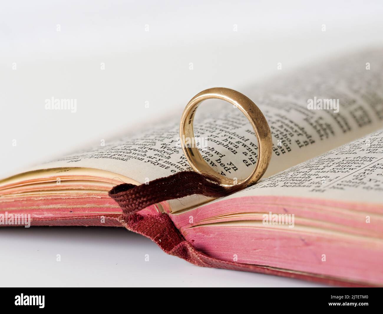 Gold wedding ring on open bible Stock Photo Alamy