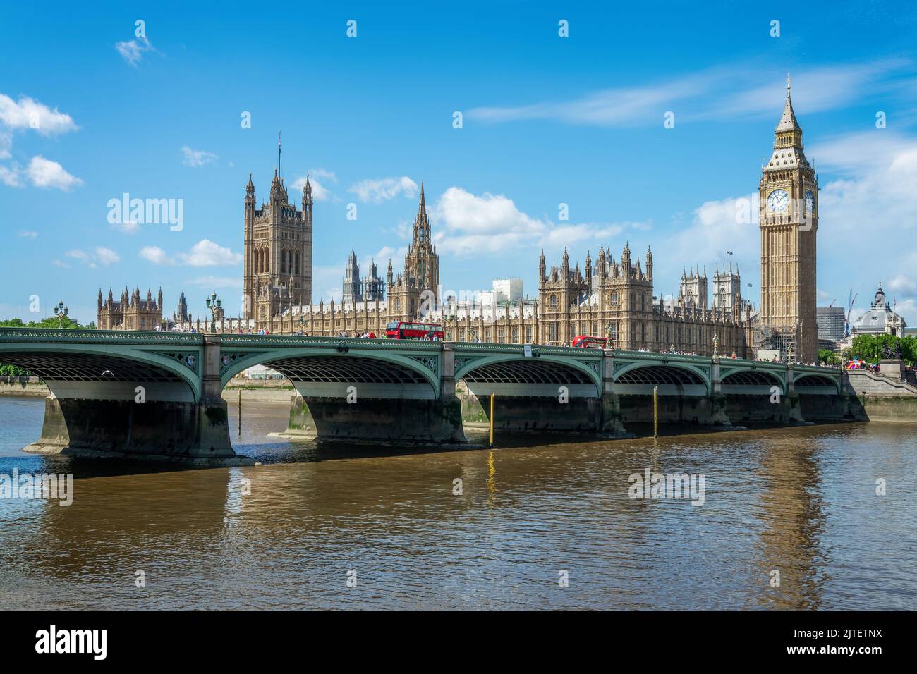 Red buses on Westminster bridge over river Thames, Big Ben and the houses of parliament in London, UK Stock Photo