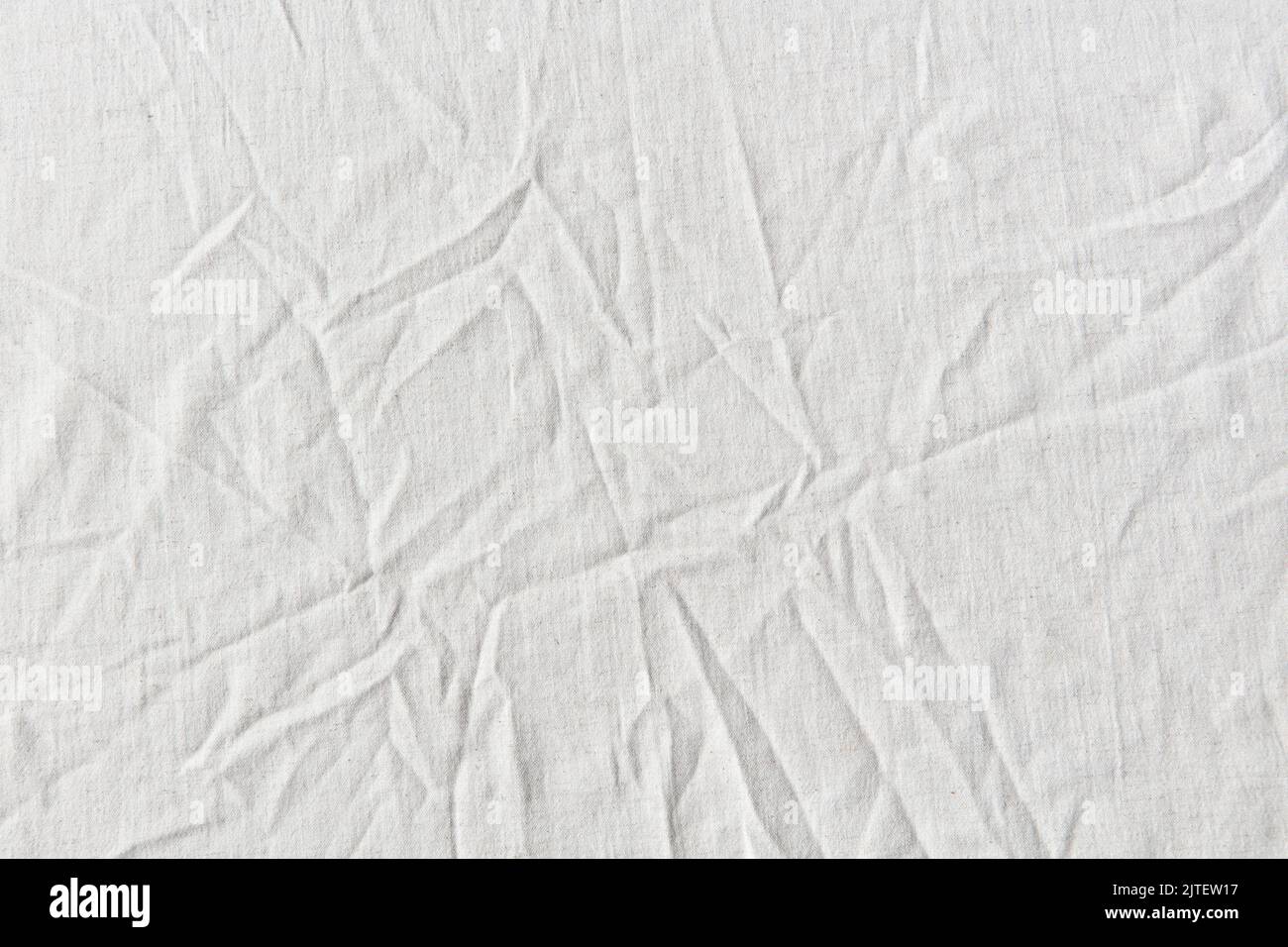 Natural crumpled white linen textile. Stock Photo