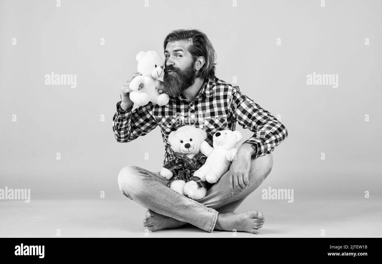 kiss of love. cheerful bearded man kissing teddy bear. male feel playful with bear. brutal mature hipster man play with toy. happy birthday. being in Stock Photo