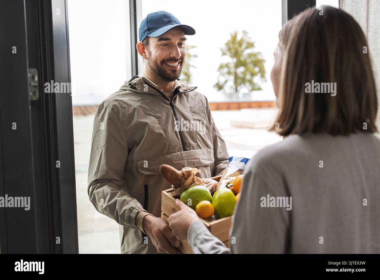 food delivery man giving order to female customer Stock Photo Alamy